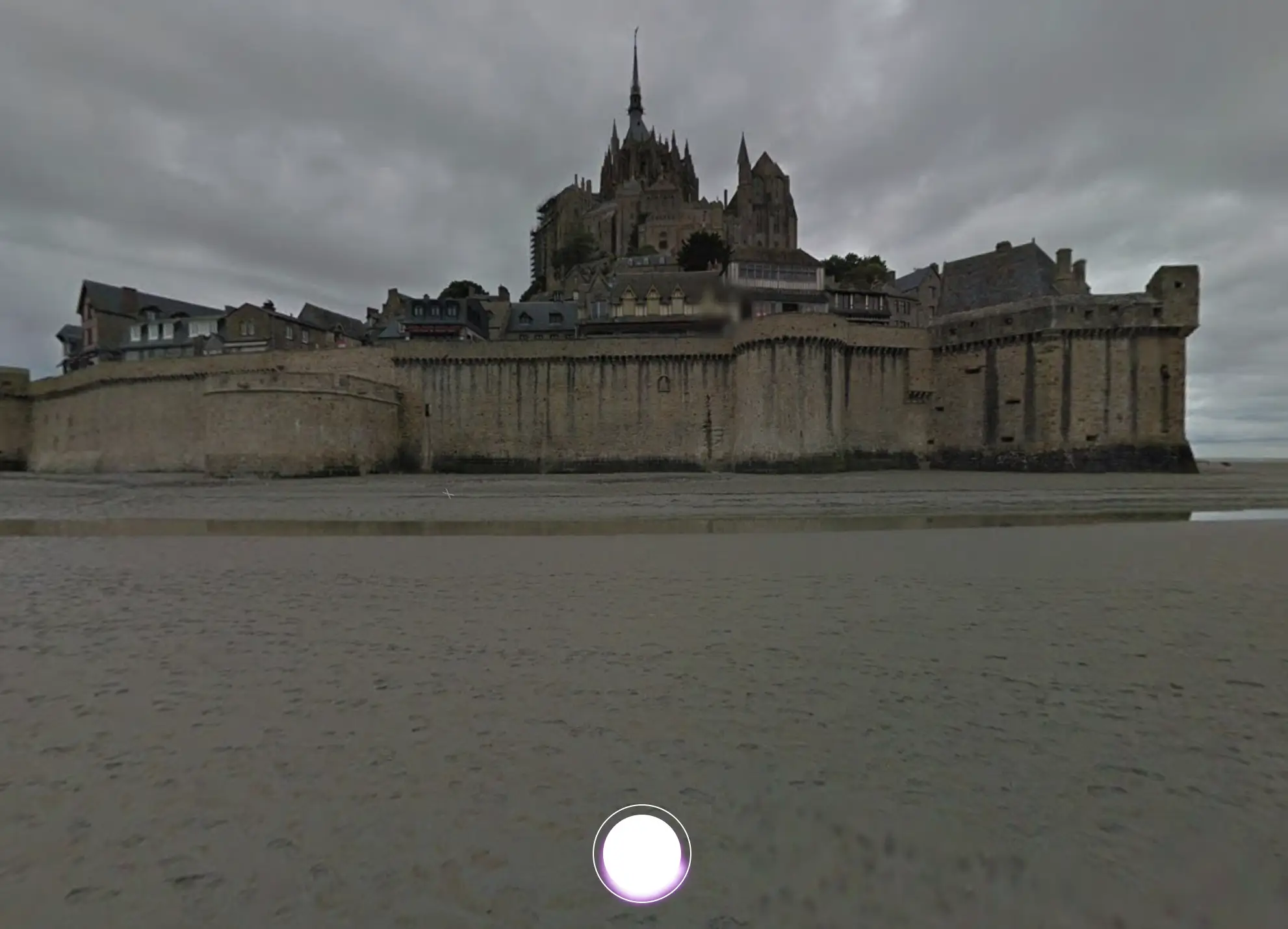 Screenshot from Google Arts & Culture’s Talking Tours, showing Mont Saint-Michel, the historic island commune in Normandy, France, with its distinct medieval architecture and surrounding sandy tidal area.