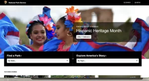 Image on the National Park Service website celebrating Hispanic Heritage Month. Features two smiling dancers in vibrant, floral traditional dresses, symbolizing cultural heritage and celebration.