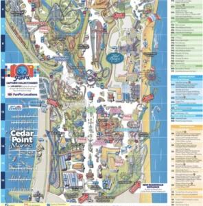 An overhead view of Cedar Point amusement park map showing roller coasters, attractions, food stalls, and walkways, surrounded by Lake Erie on one side. Key locations are labeled with a numbered index for reference.