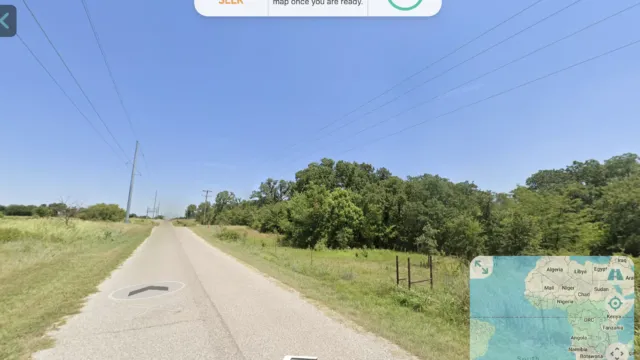 Gameplay from Hide & Seek World showing a Street View image of an open road surrounded by greenery, with instructions prompting the player to guess the hiding location.